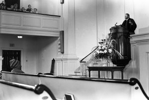 Rev. Eaton delivers a sermon from the All Souls pulpit, March 1974