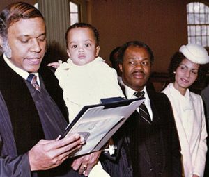 Rev. Eaton dedicates Marion Christopher Barry, seen with his parents, DC Mayor Marion Barry and Effi Barry, January 17, 1981