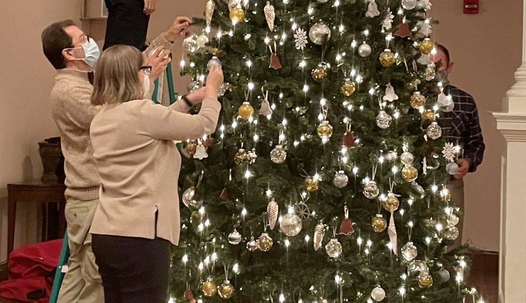 Picture of congregants decorating the Sanctuary tree.